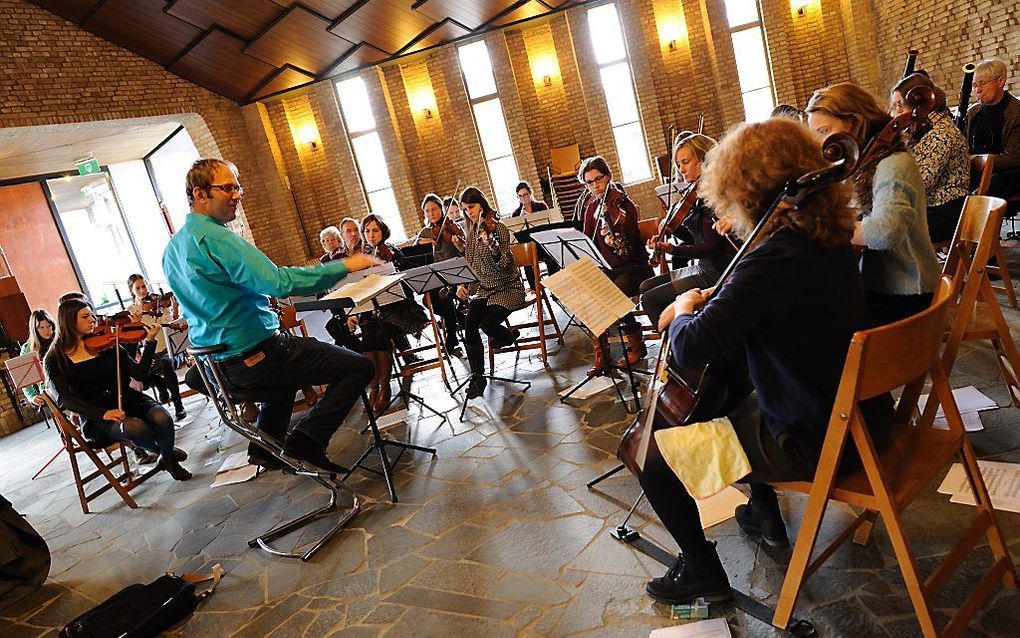 Dirigent Patrick van der Linden neemt na tien jaar afscheid van christelijk symfonieorkest Sjosjanim. „Als mensen graag klassieke muziek spelen en een uitdaging zoeken, dan zijn ze bij Sjosjanim aan het juiste adres.” Foto: dirigent en orkest aan het werk