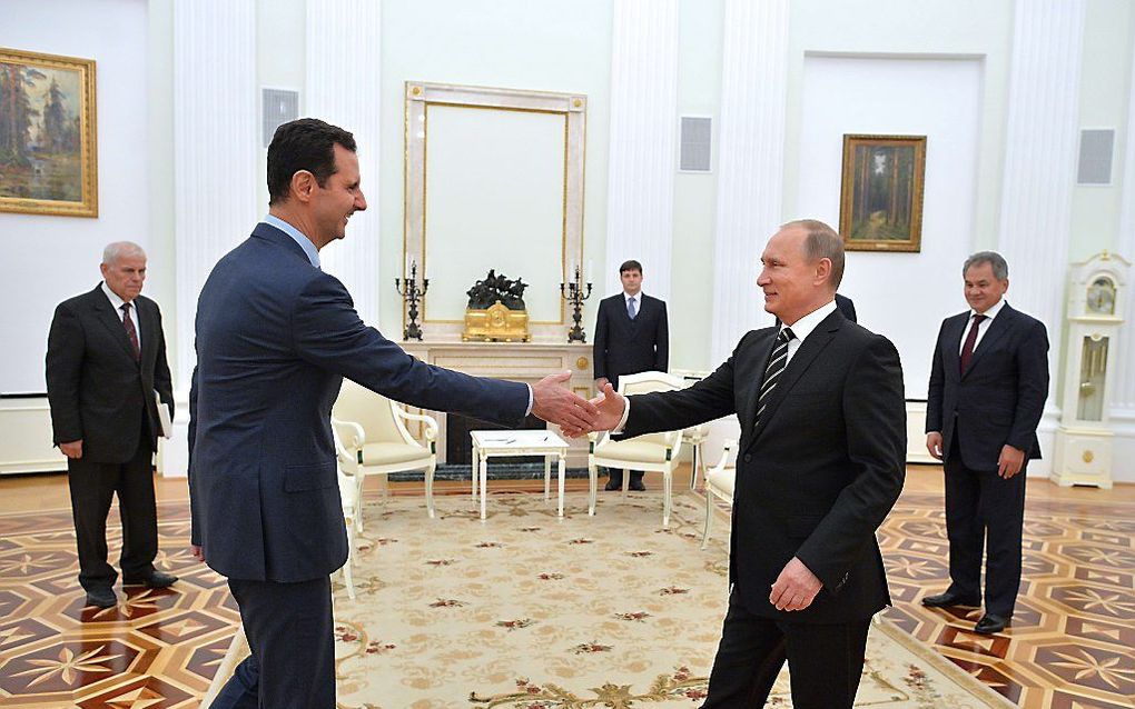 Assad (l.) op bezoek bij Putin. beeld AFP