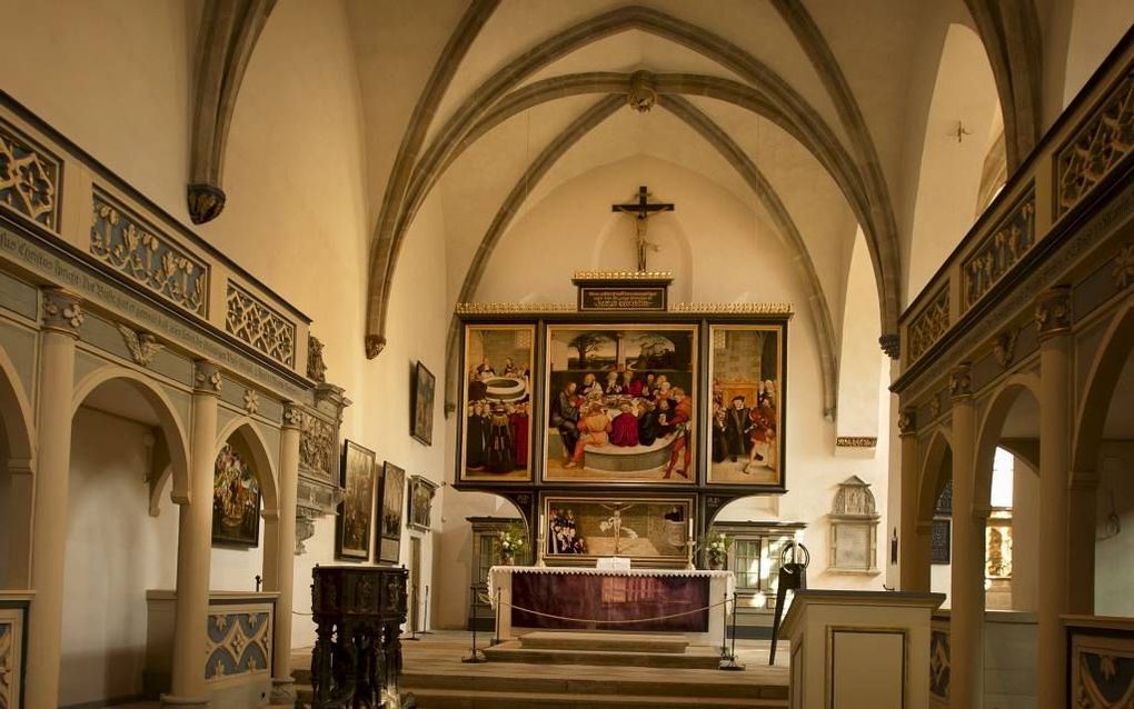 Het altaarschilderij van Lucas Cranach in de Stadskerk van Wittenberg. beeld RD, Henk Visscher