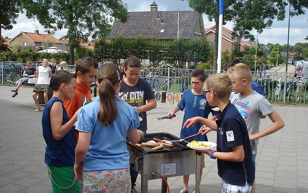 Leerlingen van groep acht van de reformatorische Ds. Joh. Groenewegenschool in Werkendam nemen afscheid van school met een barbeque. beeld Groenewegenschool