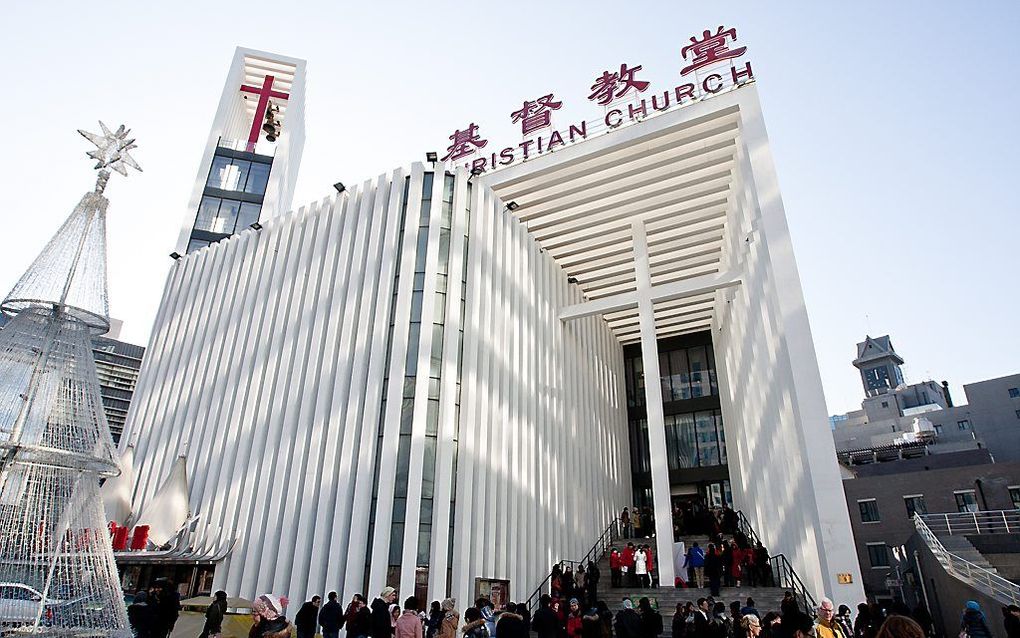 Christenen staan na een dienst te praten bij de grootste kerk van Peking. beeld Marten Visser / OMF