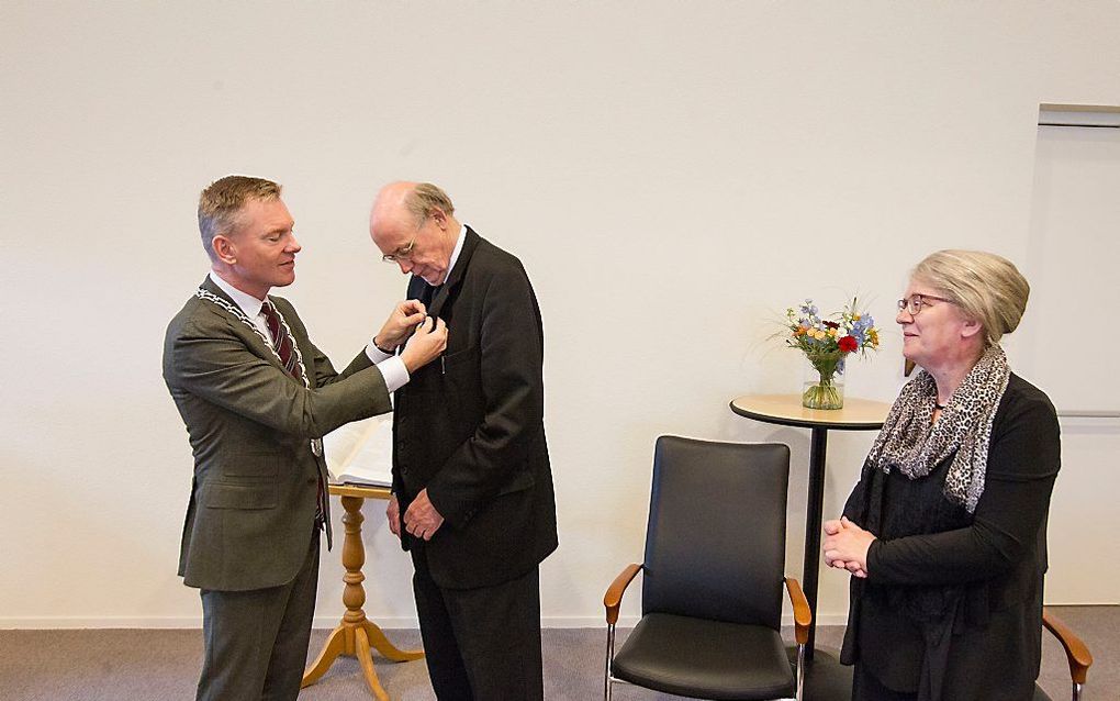 Burgemeester J. P. Rehwinkel (Zaltbommel) speldt de koninklijke onderscheiding op bij ds. A. C. Rijken. beeld RD, Anton Dommerholt