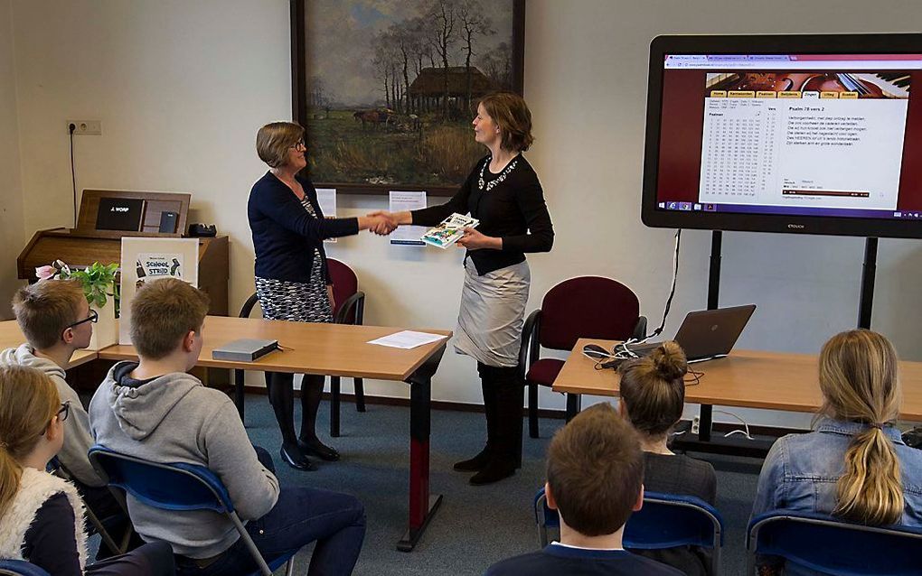 Schrijfster Marian Schalk-Meijering krijgt het eerste exemplaar overhandigd van het leesboek ”Schoolstrijd.” beeld RD, Anton Dommerholt