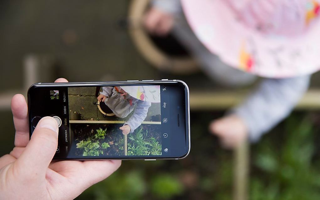 Een kind op een onherkenbare manier op de foto voor sociale media. beeld Jaco Hoeve