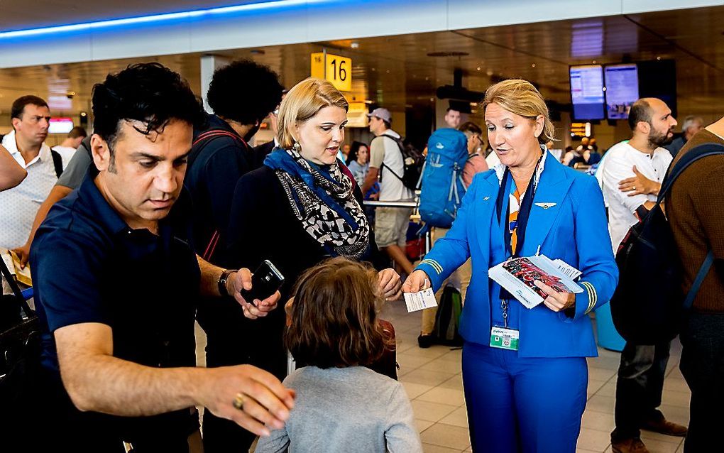 Werknemers van KLM deelden vorige week flyers uit aan reizigers op Schiphol. Een deel van het grondpersoneel van KLM legde het werk neer. Ze voeren actie om hun cao-eisen kracht bij te zetten. beeld ANP