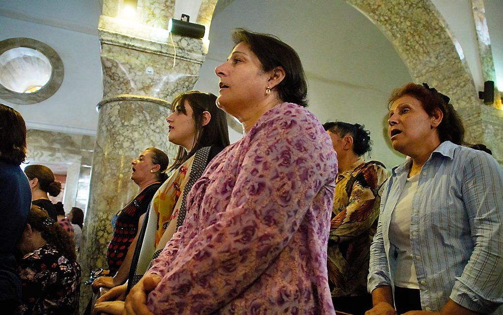 Christenen tijdens een kerkdienst in de Johannes de Doperkerk in Qaraqosh. beeld Jaco Klamer