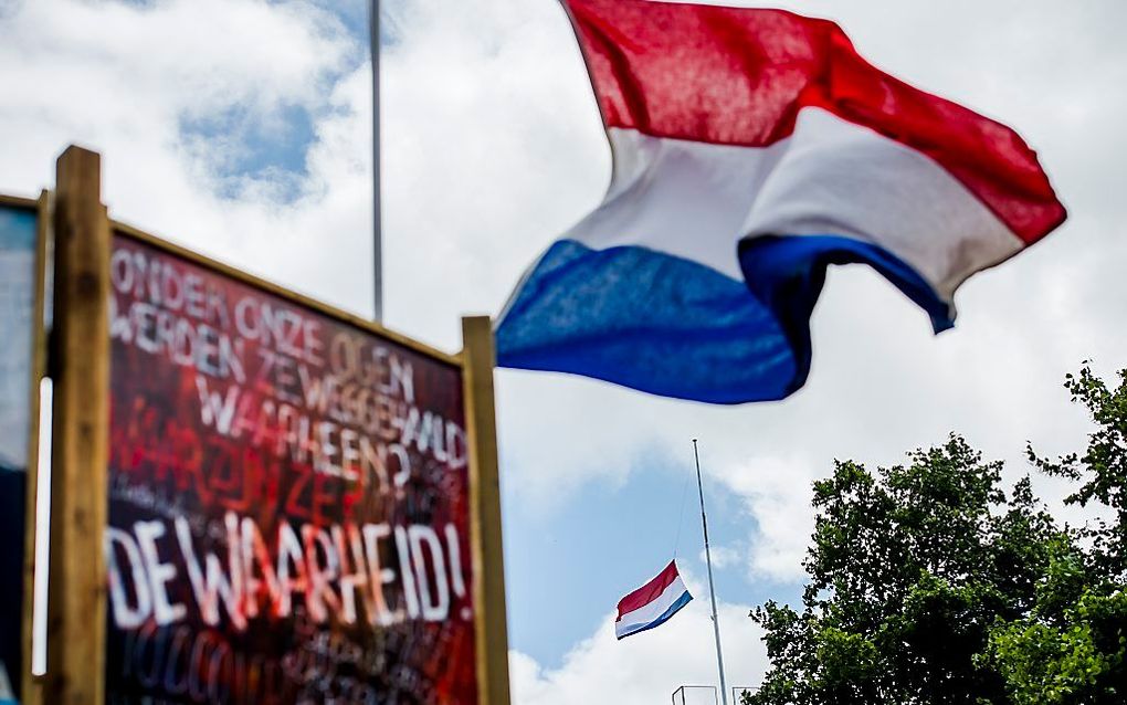 Bij de herdenking van de val van de Bosnische enclave Srebrenica hangt de vlag op het ministerie van Defensie voor het eerst halfstok. Vanaf nu gebeurt dat bij elke herdenking. beeld ANP