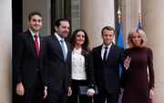 De Franse president Emmanuel Macron (2e van rechts) en zijn vrouw Brigitte (r.) poseren met de Libanese premier Saad Hariri (2e van links), zijn vrouw Lara (m.) en zijn Hussam (l.) voor het Elysee in Parijs. beeld EPA