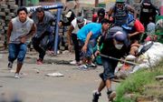 Demonstranten in Nicaragua schuilen achter een barricade tijdens gevechten met de politie, dinsdag in de stad Masaya, op zo’n 35 kilometer afstand van de hoofdstad Managua. beeld AFP, Inti Ocon