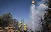 Brandweerlieden van het leger in Nieuw-Zeeland bestrijden een bosbrand in de buurt van Nelson. beeld AFP