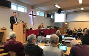 Drs. B. P. Vreugdenhil (l.), bestuursvoorzitter van de Nederlands Gereformeerde Predikantenopleiding, praat de landelijke vergadering van de NGK bij. beeld RD