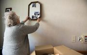 Een oudere dame bergt haar spullen op in verhuisdozen. beeld ANP