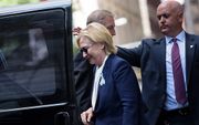 Clinton stapt, nadat ze onwel werd, in de auto. beeld AFP