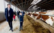 Staatssecretaris Martijn van Dam (Economische Zaken) krijgt een rondleiding op het melkveebedrijf van de 8-jarige Mika en zijn vader Jawin Klein Hegeman. beeld ANP