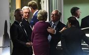May en Juncker begroeten elkaar. beeld AFP