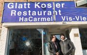 Eigenaar Baron (r.) staat met zijn vader voor het Israëlische restaurant HaCarmel. beeld ANP