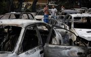 Uitgebrande auto's in Mati, een plaats in de buurt van Athene. beeld EPA