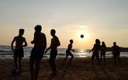 Strandbezoekers genieten begin deze maand van een potje voetbal op een strand bij de zuidelijke Siciliaanse plaats Cava d’Aliga. beeld AFP, Ludovic Marin