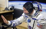 Astronaut Nick Hague zwaait voor de lancering van de raket. beeld EPA