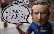 Een betoger met een masker van Facebook-topman Mark Zuckerberg staat bij Portcullis House, waar het Britse parlement samenkomt. De man toont daarmee zijn ongenoegen over het feit dat Zuckerberg niet is komen opdagen voor de hoorzitting over fake news in L