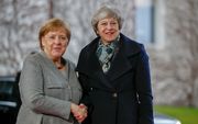 Merkel (links) en May schudden elkaar dinsdag de hand. beeld AFP