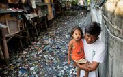 Het monster van plastic wordt door bedrijven als Unilever letterlijk en figuurlijk gecreëerd in een land als de Filipijnen. Foto: een door plastic en ander afval vervuilde watergang in de Filipijnse hoofdstad Manila. beeld AFP, Noel Celix