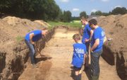 DALFSEN. Archeoloog Henk van der Velde (l.) doet voor hoe vrijwilligers bodemonderzoek kunnen doen in een oude, blootgelegde weg in een streek waar ooit hunebedbouwers moeten hebben gewoond. beeld RD