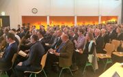 Bezoekers aan het symposium in Dordrecht zaterdag, tijdens de samenzang. beeld RD