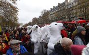 Als ijsbeer verklede activisten in Parijs. beeld AFP