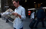 Een Brit leest de London Evening Standard, vrijdagmiddag. beeld AFP