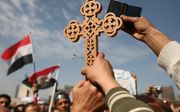 Tijdens een demonstratie in Egypte in februari vorig jaar hield iemand een koptisch kruis omhoog. Foto EPA