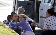 Een Israëlisch gezin uit de plaats Kiryat Malachai schuilde achter een auto voor een raketaanval vanuit de Gazastrook. Foto EPA
