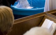 Foto: in september 2012 gaan in een dienst van de hervormde wijkgemeente Binnenstad-Vrijenban in de Nieuwe Kerk van Delft twee vrouwen onder in het doopwater. Foto Pieter Haringsma