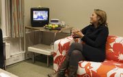 PvdA-Tweede Kamerlid Lea Bouwmeester kijkt naar de tv-uitzending van koningin Beatrix waar zij haar aftreden aankondigt. Foto ANP