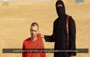 Hij bracht de westerse wereld in rep en roer, “Jihadi John”, de gemaskerde IS-strijder met zijn Britse accent. Hier naast de Britse gijzelaar David Haines, voordat hij zijn slachtoffer ter dood brengt. beeld AFP