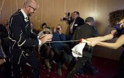 De Belgische premier Charles Michel is in Namen bekogeld met patat met mayonaise. Hij hield daar maandag een toespraak, maar die werd bij aanvang verstoord door de met friet bewapende actievoerders. beeld ANP