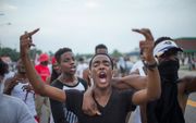 FERGUSON. Grimmige taferelen, gisteren in de Amerikaanse stad Ferguson, waar de gewelddadige dood van de zwarte Michael Brown  werd herdacht. beeld AFP
