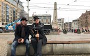 Twee Britten eten een broodje op een betonblok in Amsterdam. beeld Gerard ten Voorde