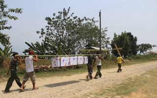 Schouder aan schouder dragen de soldaten van de Kachin Independence Army een gesneuvelde kameraad naar zijn laatste rustplaats in het noorden van Birma. Foto EPA