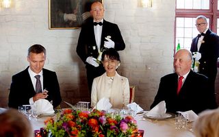 Suu Kyi geflankeerd door premier Stoltenberg en koning Harald, tijdens een diner in Akershus Castle in Oslo.   Foto EPA