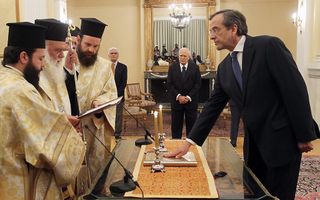 Samaras wordt ingezworen als de nieuwe Griekse premier door de aartsbisschop van Athene. Foto EPA