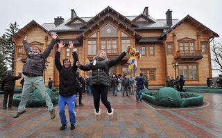 Inwoners van Kiev vieren feest bij het presidentieel paleis van Victor Janoekovitsj. beeld AFP