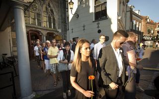In Amersfoort herdachten woensdag ruim 1000 mensen de slachtoffers van de vliegramp in Oekraïne. Na afloop legden ze bloemen op het plein voor de kerk. beeld RD, Henk Visscher