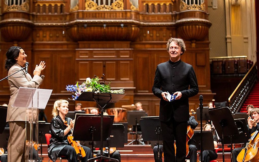 Dirigent Marc Albrecht, zaterdag bij zijn afscheid als chef-dirigent van het Nederlands Philharmonisch Orkest. Hij kreeg een koninklijke onderscheiding uit handen van de Amsterdamse wethouder voor Cultuur, Touria Meliani. beeld via orkest.nl / Melle Meivo