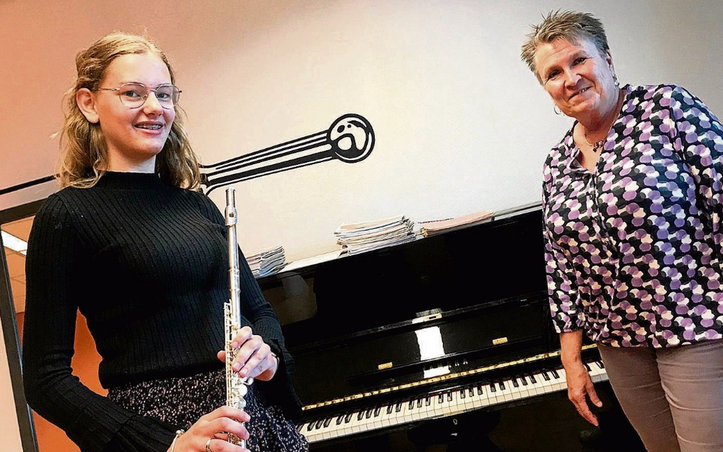 Dwarsfluitleerling Marlinde van Reenen (l.) en dwarsfluitdocent Marion Rohaan zien uit naar de normale lessen op de Muziekschool Rijssen. beeld Gerard ten Voorde
