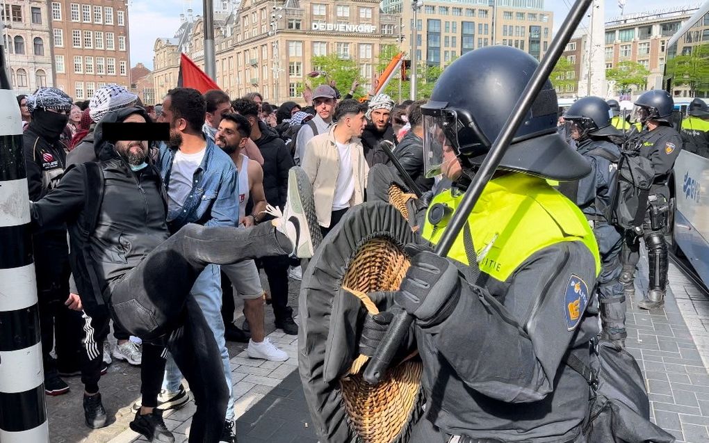 De pro-Palestijnse activist Ozan T. valt een ME’er aan tijdens de pro-Israëlactie van de SGP op de Dam. beeld RD 