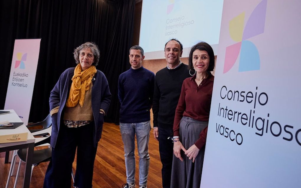 Twee vrouwen en twee mannen staan bij informatieborden met daarop de woorden ”Consejo Interreligioso vasco”.