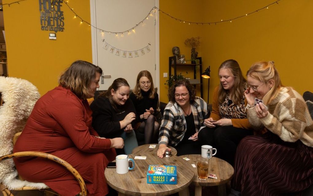 Dorathé van Leeuwen (derde van rechts) en Corieke van Veldhuizen (tweede van rechts) spelen een spelletje met cliënten van de woonlocatie van De Sleutelbloem in Driebruggen.  beeld Martin Droog