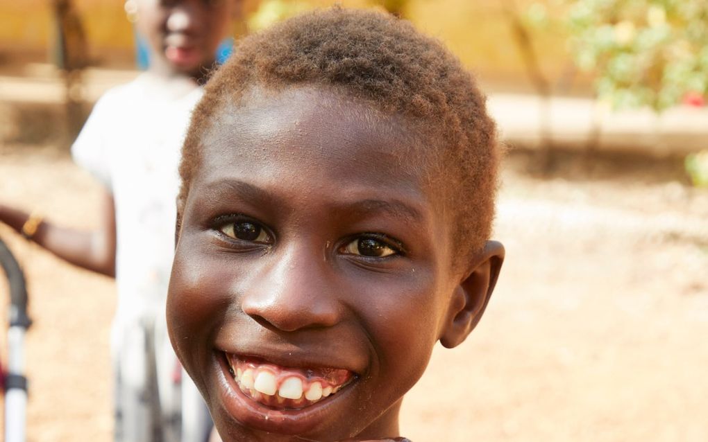 Silfano Mané doet niets liever dan iedereen een hand geven. Omdat hij een jongen met een beperking is  zit lang niet iedereen in Guinee-Bissau daar op te wachten.  beeld Jaco Klamer