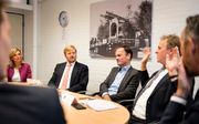 Koning Willem-Alexander luistert naar burgemeester Houben van Voerendaal die vertelt over zijn ervaringen met dreiging. beeld ANP